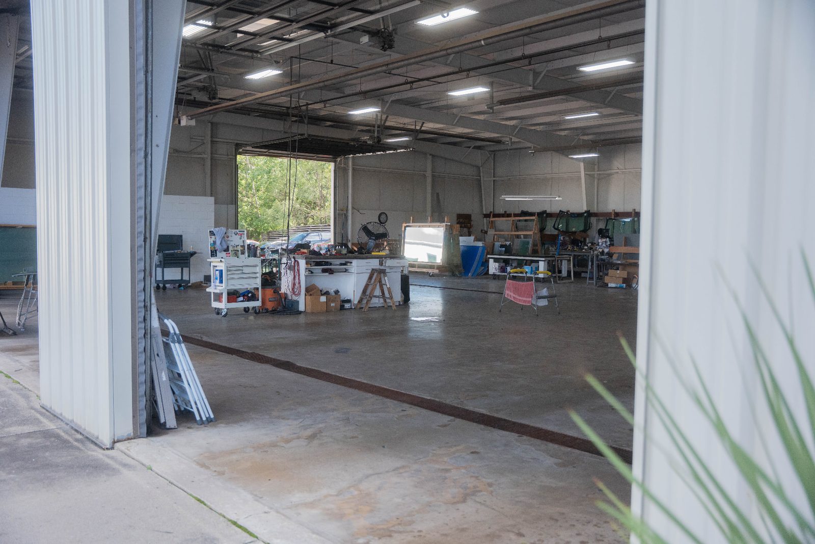 Open auto glass workshop bay with tools and glass racks