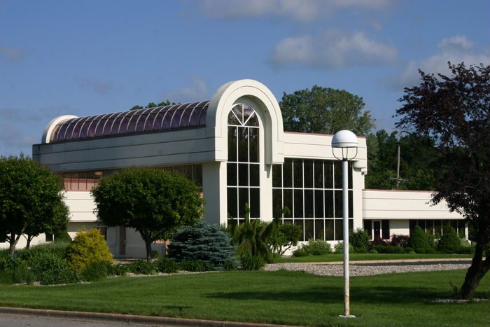 Commercial building with a tall arched window and curved glass facade
