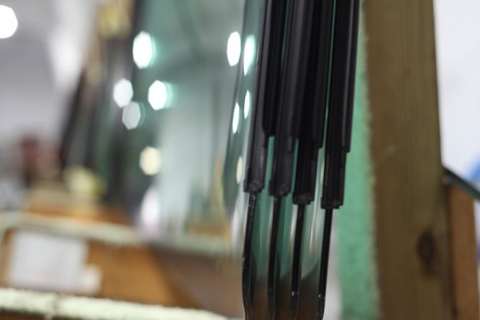 Replacement windshields stored upright in a workshop rack